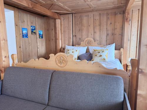 a bedroom with a large bed in a wooden wall at La Tgoma - Hotel & Restaurant in Lenz