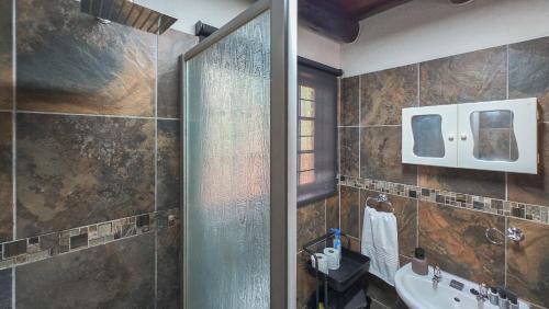 a bathroom with a shower and a sink at Inyathi Inn in Marloth Park