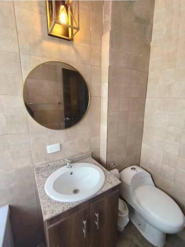 a bathroom with a sink and a toilet and a mirror at Puruha Inn in Riobamba