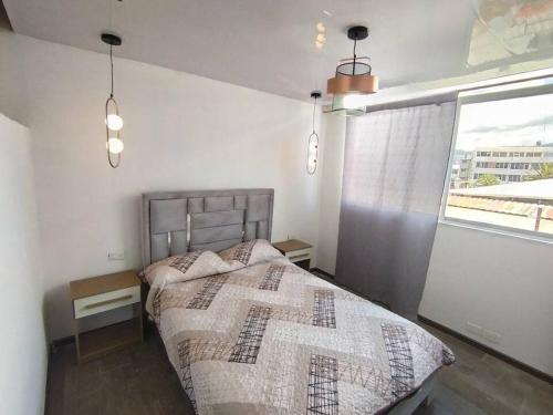 a bedroom with a bed and a large window at Puruha Inn in Riobamba