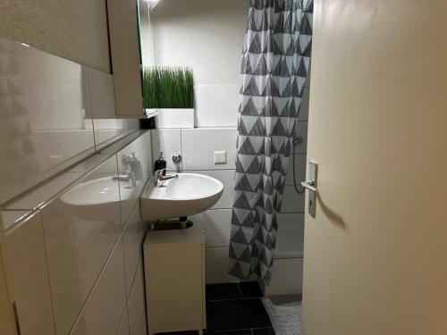 a bathroom with two sinks and a shower curtain at Goetheanum Casa in Dornach