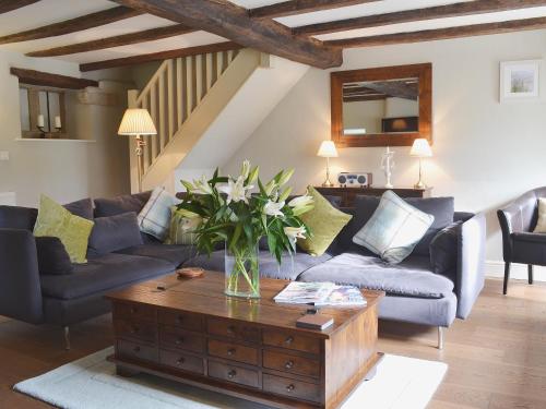 a living room with a vase of flowers on a coffee table at The Causeway in Eyam