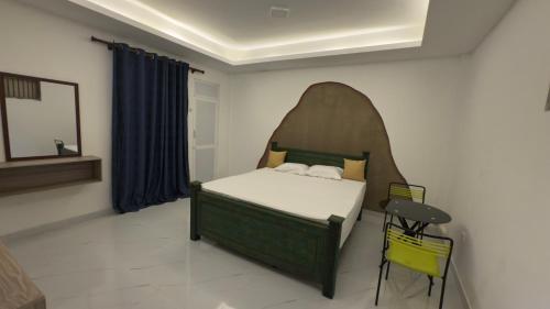 a bedroom with a bed with a headboard and a table at SeekRide Bolgoda in Bandaragama