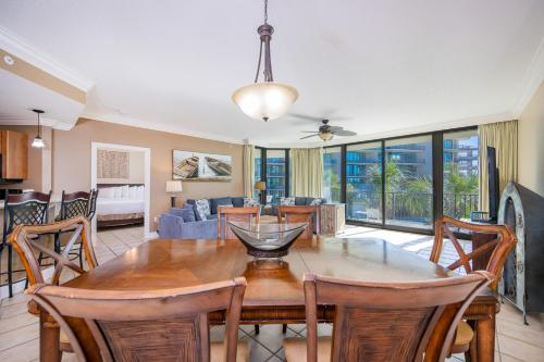 a dining room and living room with a table and chairs at Phoenix on the Bay 1211 condo in Orange Beach