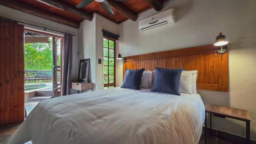 a bedroom with a large white bed with blue pillows at Inyathi Inn in Marloth Park