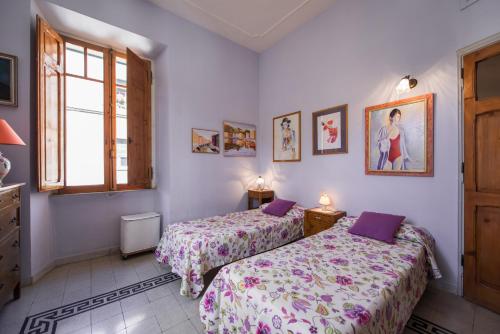 ローマにあるColosseo Holiday Houseのベッドルーム1室(ベッド2台、窓付)