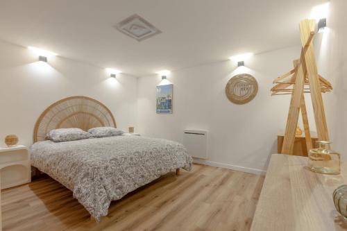 a bedroom with a bed and a wooden floor at Le Ciné Lodge Provence in Flassans-sur-Issole