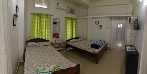 a bedroom with two beds and a tv in it at La Paloma in Dispur