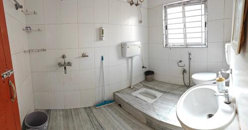 a bathroom with a sink and a toilet at La Paloma in Dispur