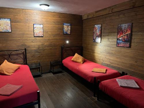 two beds in a room with wooden walls at Fundalucia Guesthouse in Quéntar