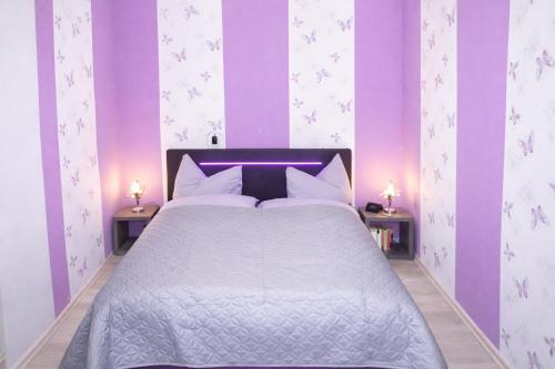 a bedroom with a bed with purple and white walls at Ferienwohnung Zur Rennsteigruh in Ruhla