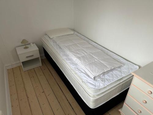 ein Bett in einem Zimmer mit einem Nachttisch und einem Bett sidx sidx sidx sidx in der Unterkunft Plads til 5 in Samsø