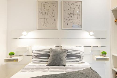 a bedroom with white walls and a bed with striped pillows at Beach House Old Town in Cascais