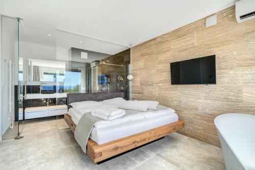a bedroom with a bed and a tv on a wall at Villa Luca in Seget Vranjica