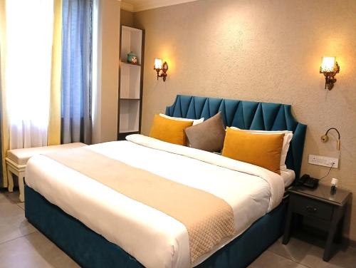 a hotel room with a large bed with yellow pillows at Maheshwari international in Lansdowne