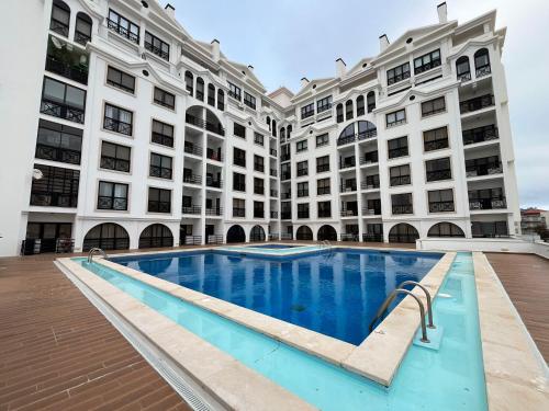 a large building with a swimming pool in front of it at Sunset Bay São Martinho do Porto in São Martinho do Porto