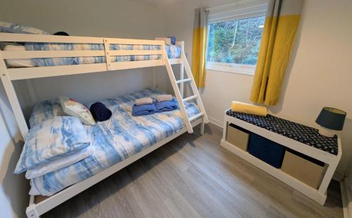 a bedroom with two bunk beds and a window at Cabin 246 Riverside, Glan Gwna in Caeathro