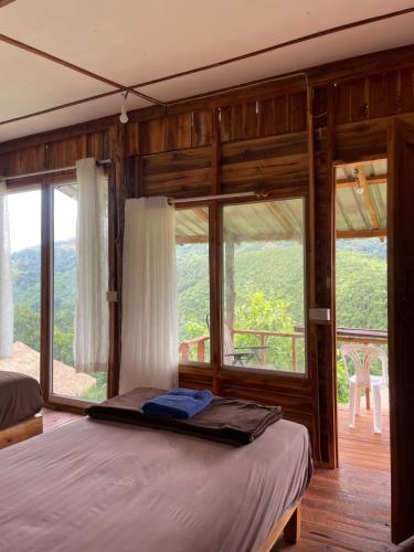 a bedroom with a bed and a large window at Sapan Goodview สะปันกู๊ดวิว in Ban Na Luang