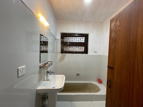 a bathroom with a tub and a sink and a bath tub at Sun Rise Cottage in Kathmandu
