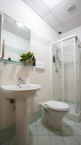 a bathroom with a sink and a toilet and a shower at Hotel Gangi in Piazza Armerina