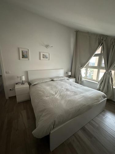 a white bedroom with a large bed and a window at La Villa - Il Loft in Frosinone