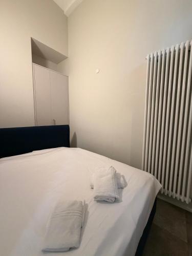 a white bed with two white towels on it at Appartamenti Music 2 - Light and Shadows 3 - Estival 4 - Blues 5 in Muralto