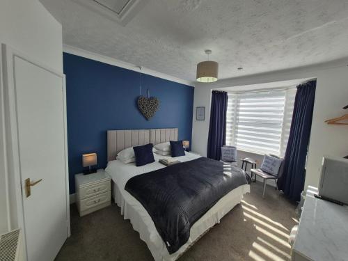 a bedroom with a blue wall and a bed at The Clifton at Paignton in Paignton