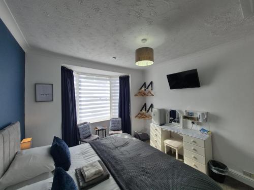 a bedroom with a bed and a desk at The Clifton at Paignton in Paignton