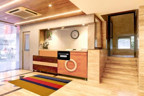 a lobby with a counter and a clock on the wall at Super Townhouse Oak Madhapur Nera Regency in Hyderabad