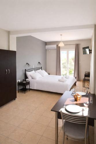 a bedroom with a bed and a table and chairs at Rodanthy II in Katelios