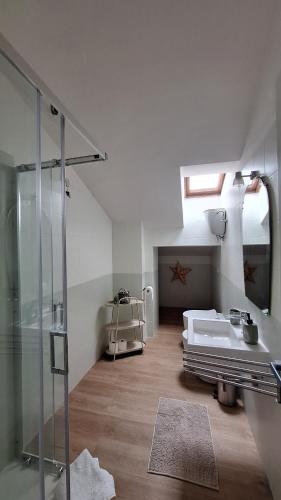 a bathroom with a glass shower and a sink at L'Attico Affittacamere in Santa Maria degli Angeli