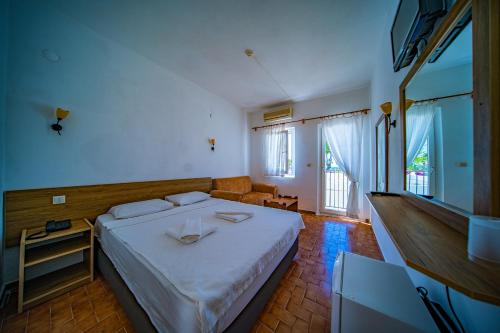 a bedroom with a bed and a couch at Nagi Beach Hotel in Gümbet