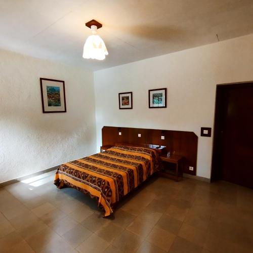 a bedroom with a bed and a light on the ceiling at BALAFON hôtel in Cap Skirring