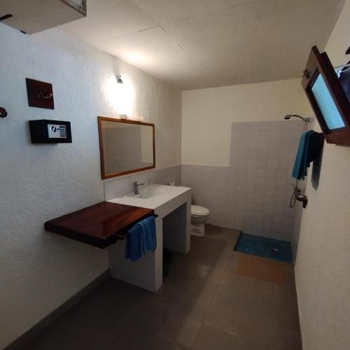 a bathroom with a sink and a toilet and a mirror at BALAFON hôtel in Cap Skirring