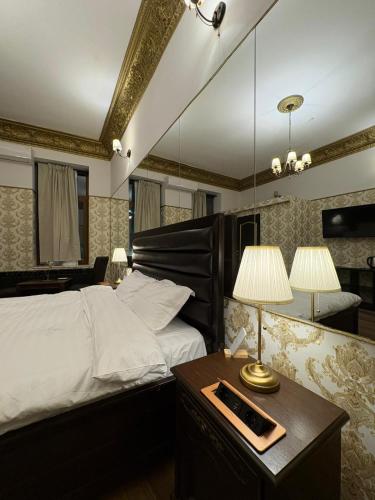 a bedroom with a bed and a table with a lamp at Villa Romana in Bucharest