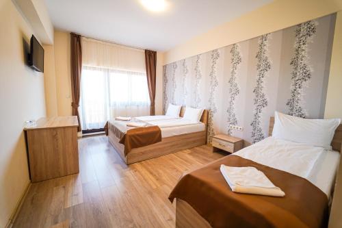 ein Hotelzimmer mit zwei Betten und einem Fenster in der Unterkunft Urusossziklakert in Dealu