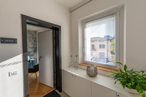 a room with a window and a door with a plant at Residence Moretti in Udine