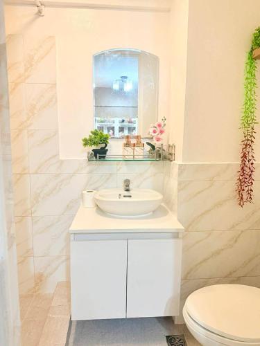 a white bathroom with a sink and a toilet at Relaxing 2BR at Camella Northpoint with balcony pool view 3rd floor in Davao City