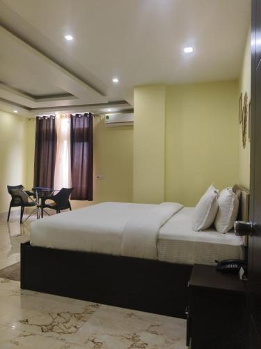 ein Schlafzimmer mit einem Bett, einem Tisch und Stühlen in der Unterkunft Hotel Hempi in Diphu