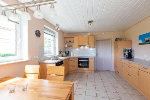 a kitchen with wooden cabinets and a wooden table at Hus-Pellworm-1-Ferienwohnung-Meerestraum in Pellworm