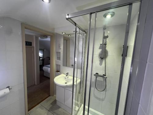 a bathroom with a glass shower and a sink at Centennial Hotel in Cambridge