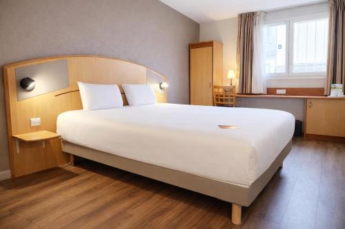 a bedroom with a large bed in a hotel room at Kyriad Hotel Montpellier Centre Antigone in Montpellier