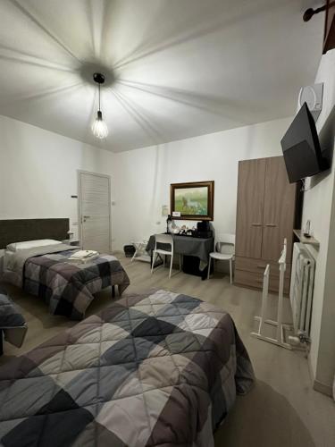 a bedroom with two beds and a desk in it at R&B Emilia in Cadeo