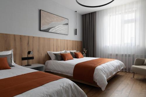 a hotel room with two beds and a chair at Kibas Hotel in Bishkek