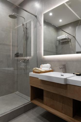 a bathroom with a sink and a shower and a mirror at Kibas Hotel in Bishkek