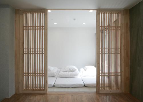 a room with a bed with white sheets and towels at Stay PLAN B in Seoul