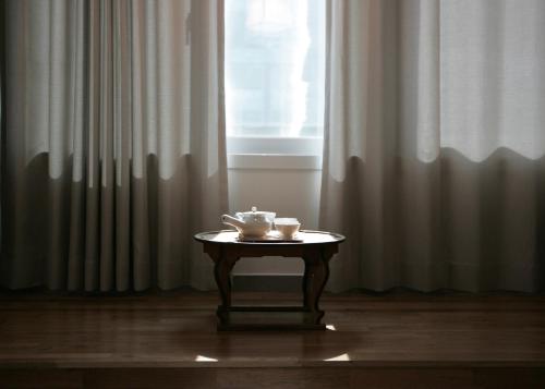 a table with two cups on it in front of a window at Stay PLAN B in Seoul