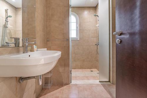 a bathroom with a sink and a shower at Specious 2BR VILLA WITH MAIDROOM AND HUGE GARDEN IN JVT DUBAI in Dubai