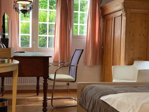 ein Schlafzimmer mit einem Bett, einem Schreibtisch und zwei Stühlen in der Unterkunft Hotel Grander Mühle in Kuddewörde