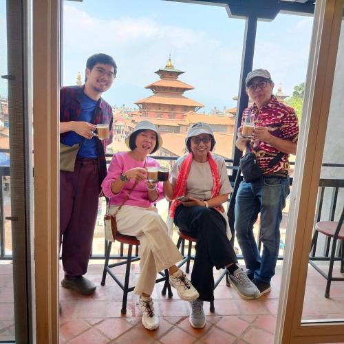 a group of people drinking wine on a balcony at Lalit Heritage Home in Pātan